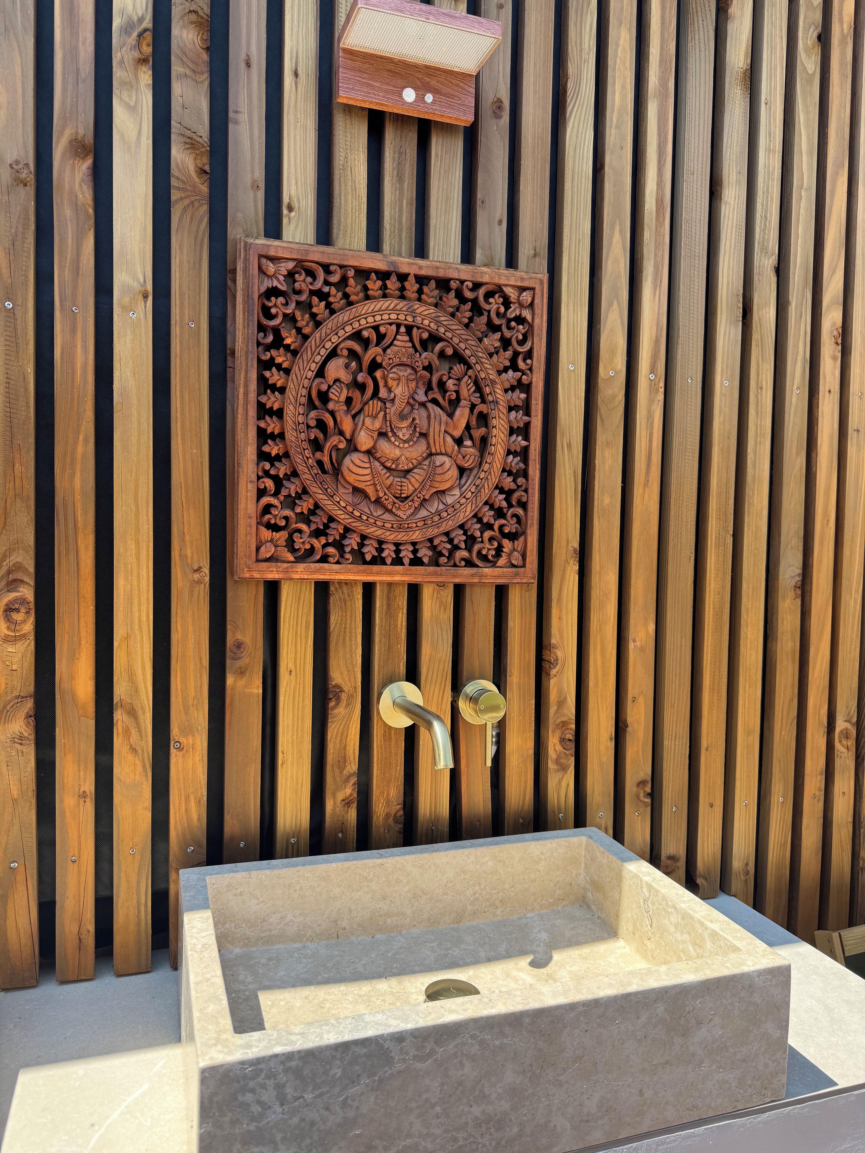 A wooden wall with a decorative panel and a built-in sink.