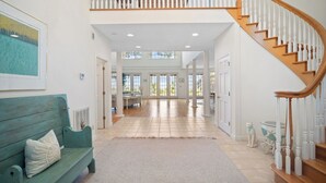 A spacious interior with a wooden staircase, a green bench, and a view into a dining area. - Ocean View, Golf Cart Included, Club Cards Available - 8 River Club (Fripp Island)