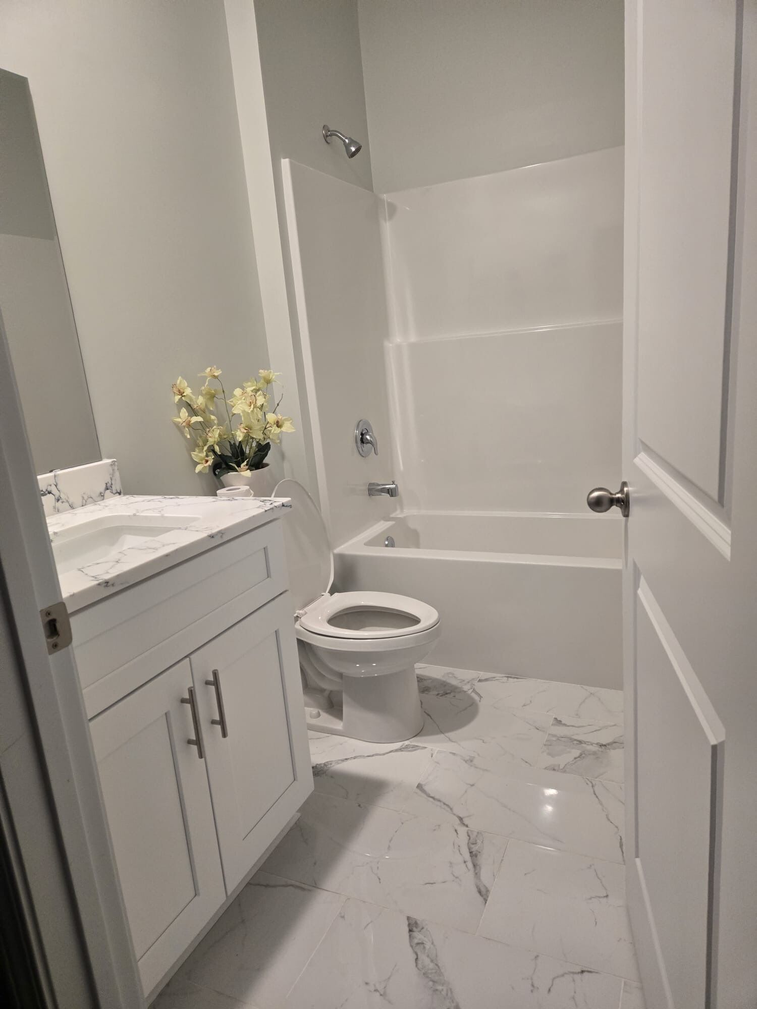 Et badeværelse med toilet, vask og badekar.