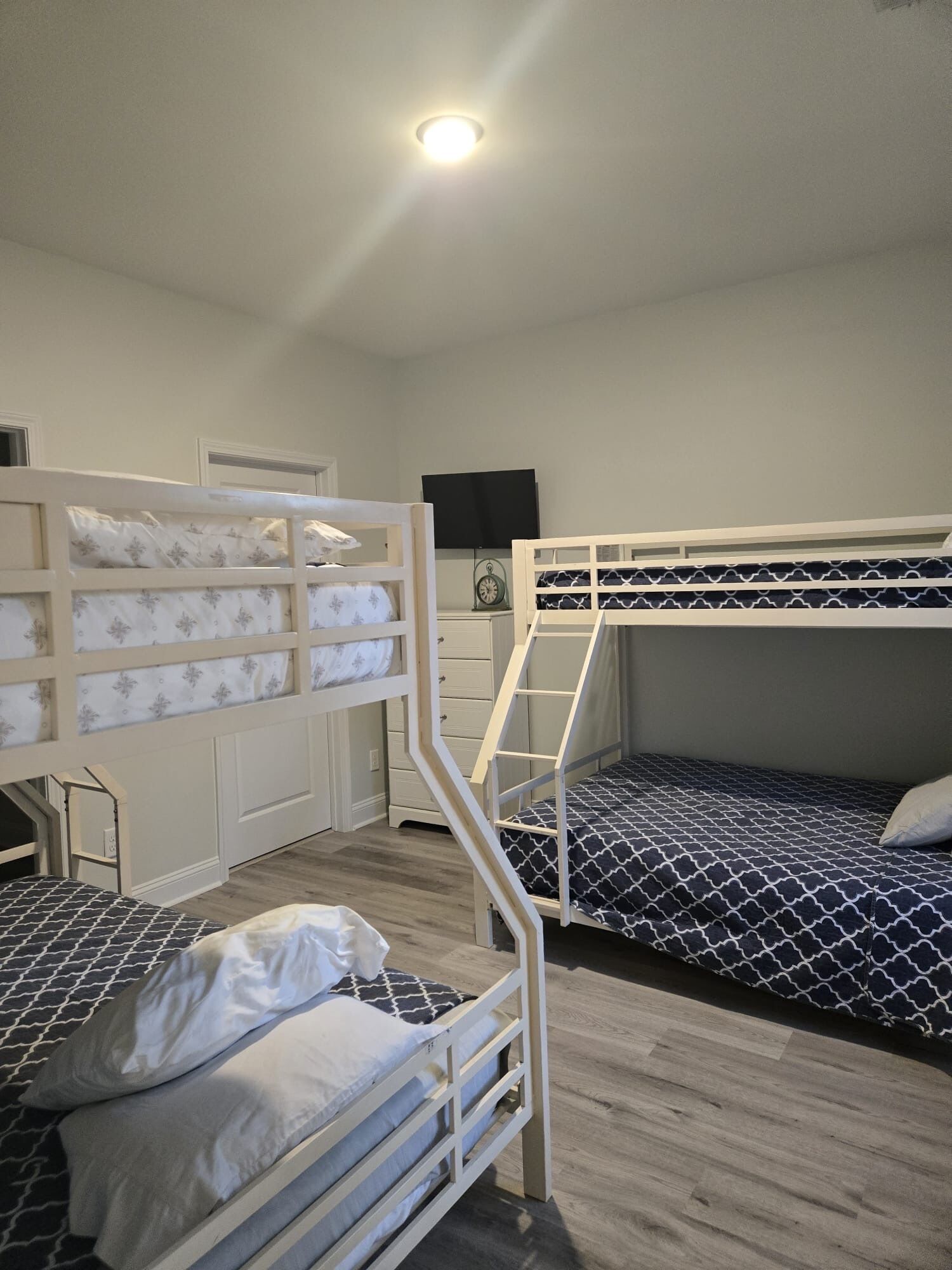 A bunk bed room with a desk and a television.