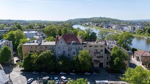 Un immeuble à plusieurs étages doté d’une cour intérieure, entouré d’arbres et de voitures garées.