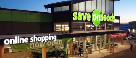 Un magasin Save on Foods avec une grande enseigne faisant la publicité des achats en ligne.
