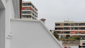A balcony with two white plastic chairs and a small round table. - Apartamentos Ritual Casablanca (Torremolinos)