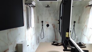 A modern bathroom with a white sink, a large mirror, and a shower area. - Apartamentos Ritual Casablanca (Torremolinos)