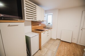 Una cucina moderna con mobili bianchi, forno integrato e una finestra con vista.