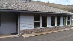 A building with a stone foundation and a grey exterior. - House right on Pine Creek, only one mile from the Snake. (Oxbow)