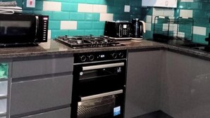 A modern kitchen with a gas stove, microwave, and double oven. - Stunning, large, 2 king sized bedroom apartment. (Glasgow)