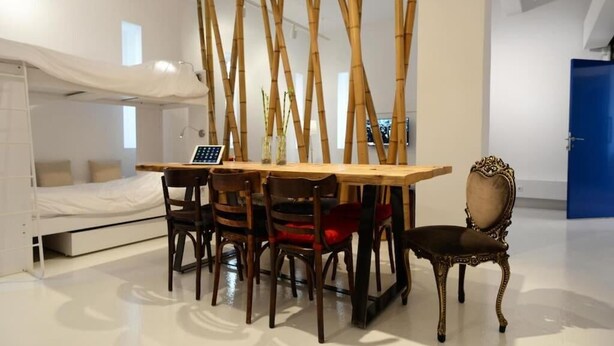A compact room with a bunk bed, a dining table with chairs, a laptop, and a decorative chair. - Super 8 (Athens)