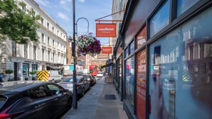 A city street with a hotel named 'easyHotel Paddington' and a cafe named 'Cafe de Paris.' - EasyHotel Paddington (London)