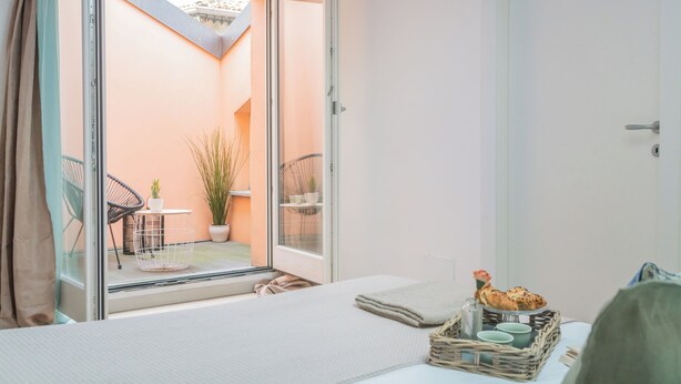 A bedroom with a bed, a window, a balcony, and a breakfast setup. - Como Sky Suite by Rent All Como (Como)