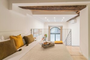 A bedroom with a bed, pillows, a tray with pastries, a window, and a staircase. - Como Loft & Charme by Rent All Como (Como)