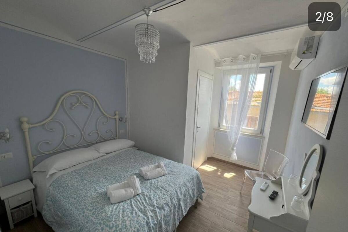 A bedroom with a bed, bedside table, and a bathroom with a sink and mirror.