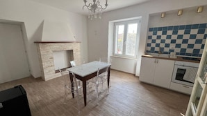 A spacious kitchen with a tiled backsplash, a dining area with a table and chairs, and a fireplace. - Dimora dei Magi (Saturnia)