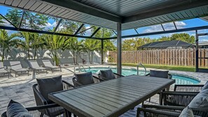 Eine Außenpatio mit Pool, Liegestühlen und einer überdachten Sitzgelegenheit.