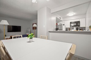 A modern kitchen with white cabinets, a microwave, and a stainless steel refrigerator. - Modern East Austin Escape - Pool - 3Mi to Downtown (Austin)