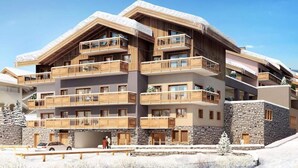 Un hotel de varios pisos con balcones de madera, fachada de piedra y cielo despejado.