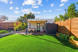A backyard with a patio, a dining table, and chairs. - Private yard|AC|EV| Relocation| Remote work (San Diego)