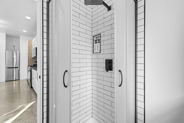 A modern kitchen with stainless steel appliances, a white tiled backsplash, and a black-framed mirror. - Private yard|AC|EV| Relocation| Remote work (San Diego)