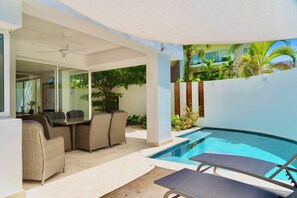 A modern outdoor pool area with a dining set and lounge chairs. - New! Cap Cana Apartment w/ Exclusive Pool & Terrace (Punta Cana)