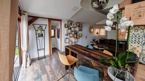Een moderne keuken met een houten tafel, stoelen en een grote hanglamp.