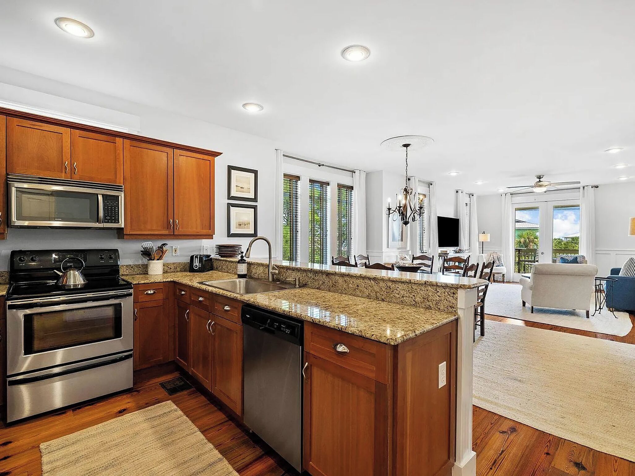 A modern kitchen with granite countertops, stainless steel appliances, and wooden cabinets.