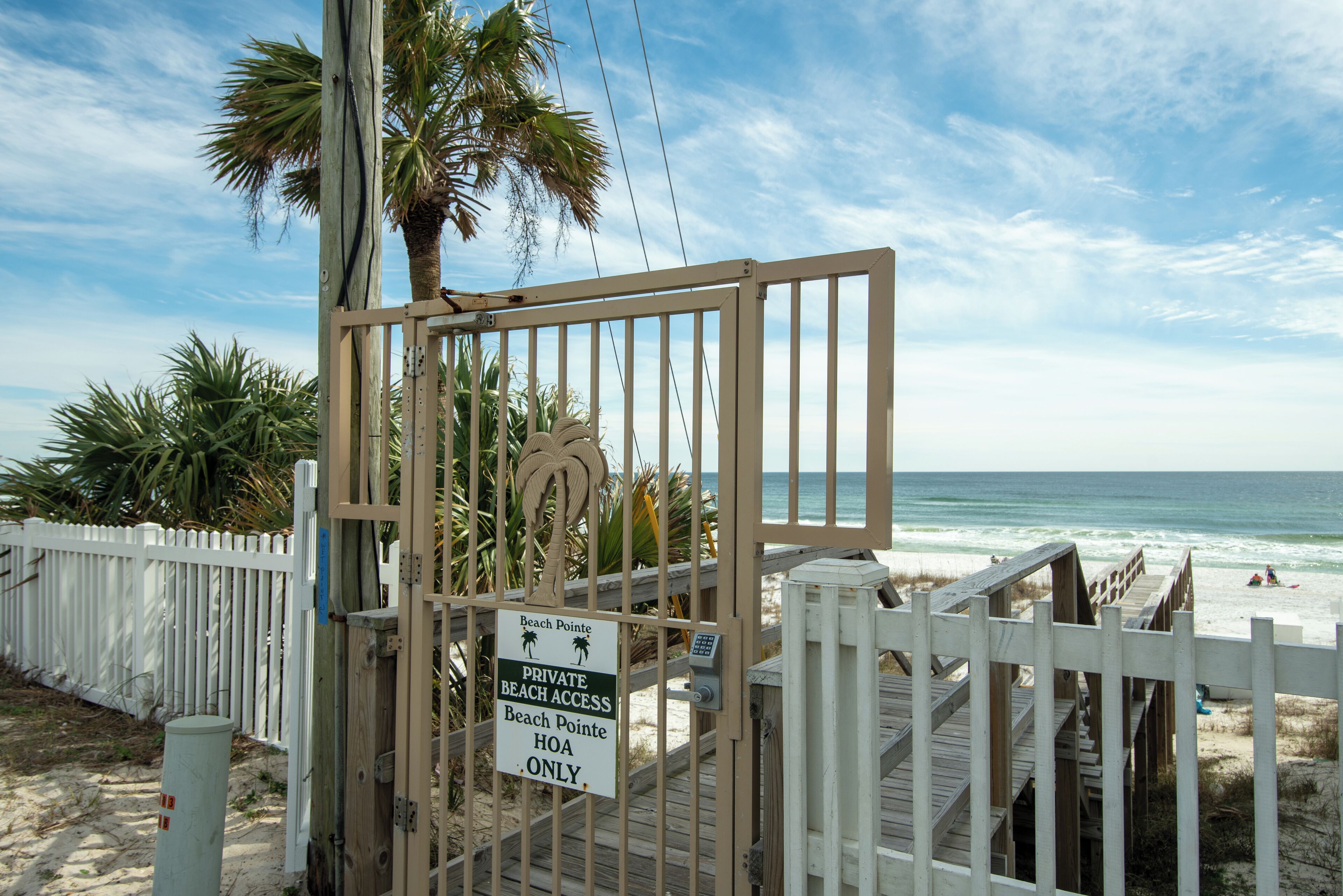 A gated beach area with a sign indicating private beach access.