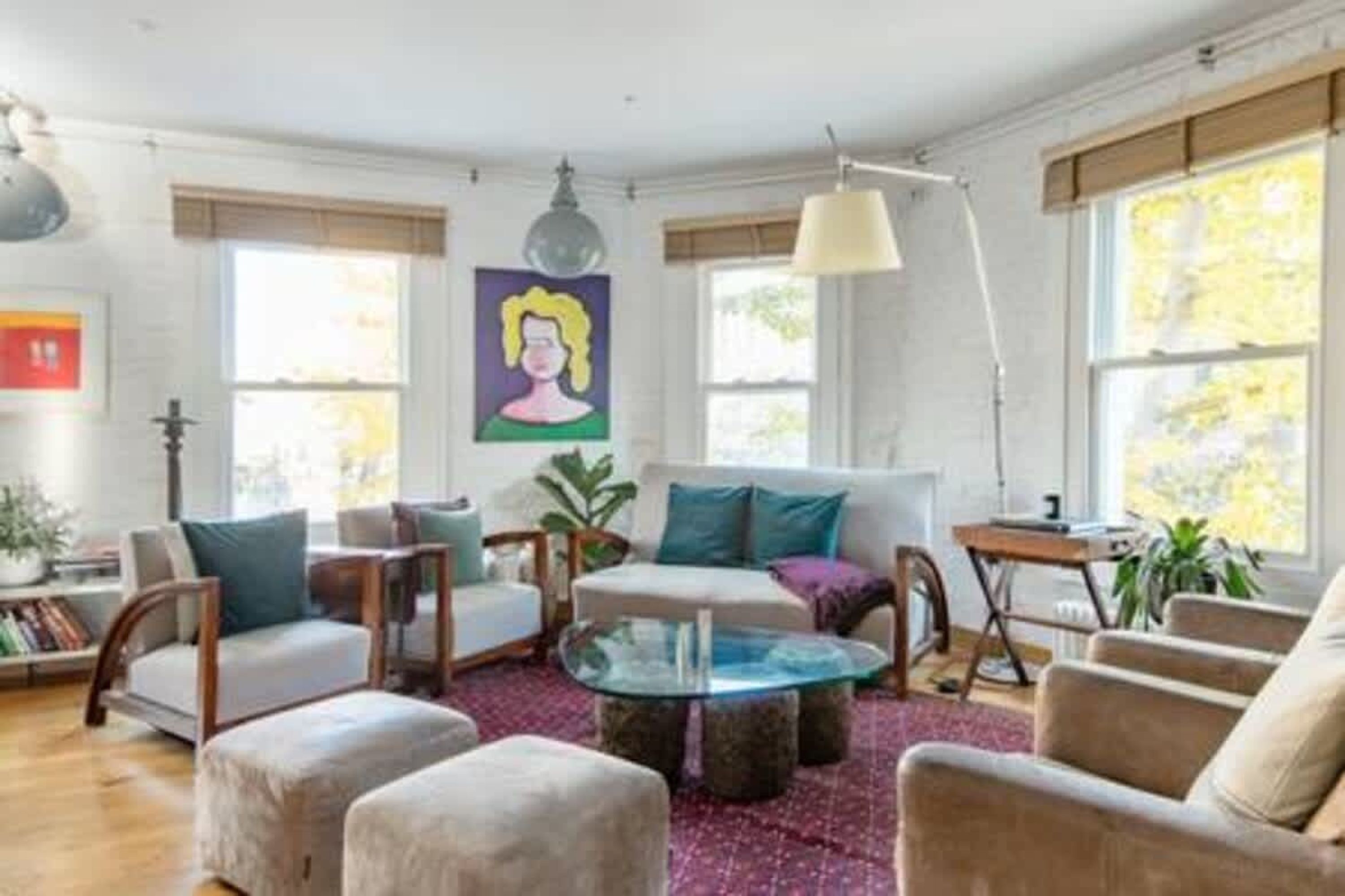 Un salon comprenant un canapé, des fauteuils, une table basse et une bibliothèque.