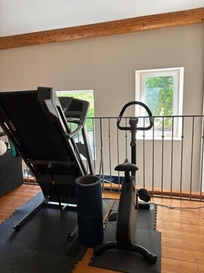 A home gym with a stationary bike, a treadmill, and exercise mats. - Mas Provençal à flanc de colline (Bollène)