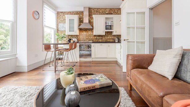 A modern kitchen with white cabinets, a brick backsplash, and a built-in oven. - Modern   Scandi-style 2bed facing Vauxhall Park (Greater London)