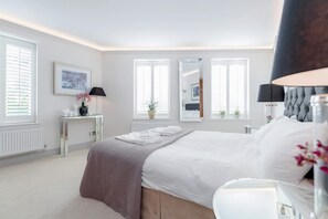 A bedroom with a large bed, bedside tables, a mirror, and a window with blinds. - Modern   Stylish 2bed 2bath close to Kings Road (London)