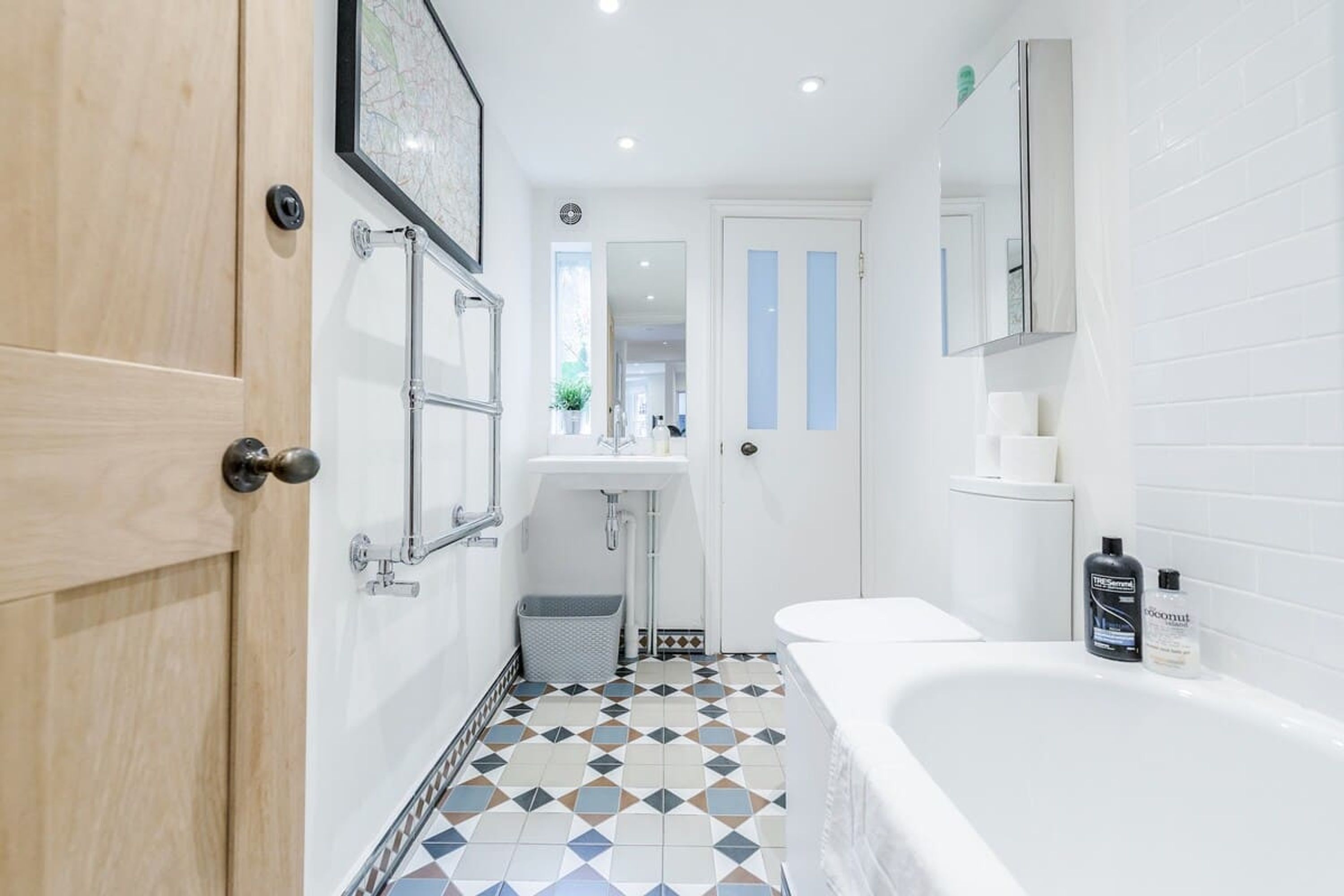 Un bagno moderno con una vasca, un lavandino e uno specchio.