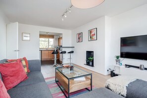 A modern living room with a glass coffee table, grey sofa, and a flat-screen TV. - Spacious 2bed in top location Holland Park-N Hill (Greater London)