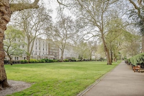 A pathway lined with trees and benches, leading to a building with multiple windows. - Spacious   modern 2bed 2 5bath in Pimlico-Victoria (Greater London)