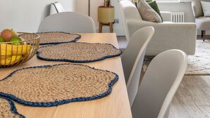 Ein modernes Wohnzimmer mit einem Holzesstisch, einer Couch und einer Stehlampe.