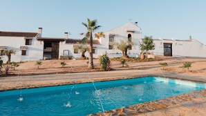 A pool with clear water, surrounded by white buildings with tiled roofs, and palm trees. - SANGHA SPACE. Entire Property, 13 Bedrooms. (Mora)