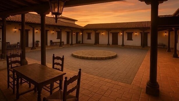 A courtyard with a round stone table and chairs, surrounded by buildings with columns and lanterns. - SANGHA SPACE. Entire Property, 13 Bedrooms. (Mora)