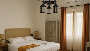 A hotel room with a bed, bedside lamps, a wardrobe, and a window with curtains. - SANGHA SPACE. Entire Property, 13 Bedrooms. (Mora)