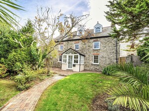 A stone house with a brick pathway leading to a small front garden. - Vosporth Villa (Newquay)
