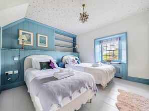 Ein Schlafzimmer mit zwei Betten, einer Decke mit Sternenmuster und einem Fenster mit Blick.