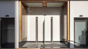 A modern elevator with a minimalist design, featuring a glass enclosure and a wooden ceiling. - Stylish Studio with Balcony & Pool View in Arjan – Close to Miracle Garden (Dubai)