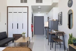 Un salon moderne comprenant un canapé, une table basse et un coin repas avec des chaises et une table.