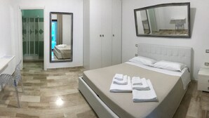 Ein Hotelzimmer mit einem Bett, einem Spiegel, einem Nachttisch und einem Sessel.