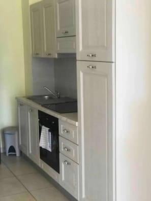 A kitchen with cabinets, a sink, and a dishwasher. - Villa Nuragica – Room with Private Bathroom and Pool View (Nuraxi Figus)