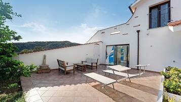 A patio with outdoor furniture, a stone pillar, and a view of the landscape.