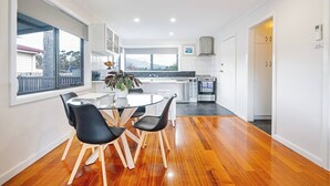 A modern kitchen with white cabinets, a built-in oven, and a large window.
