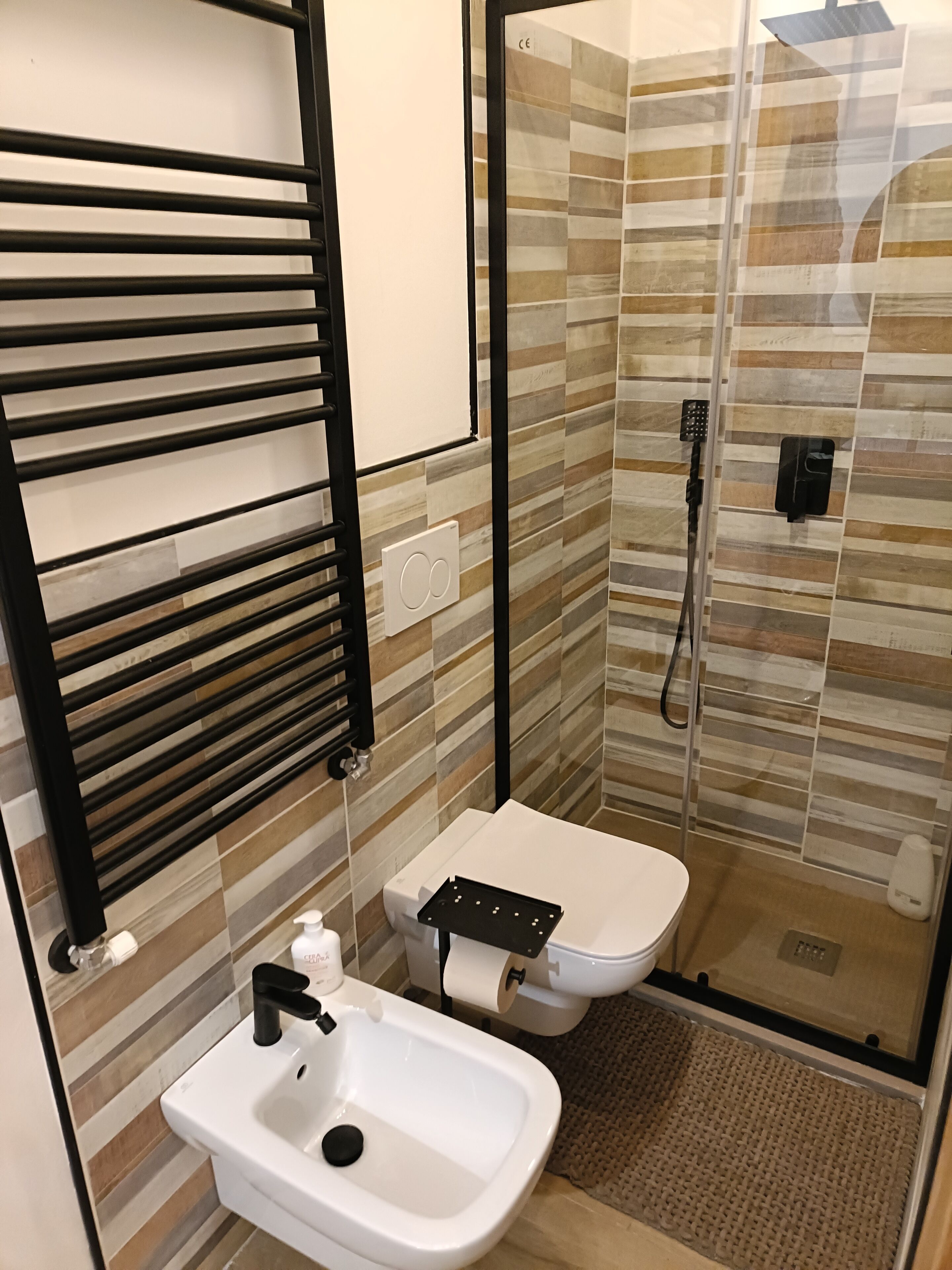 Une salle de bain avec des toilettes, un lavabo et une douche.