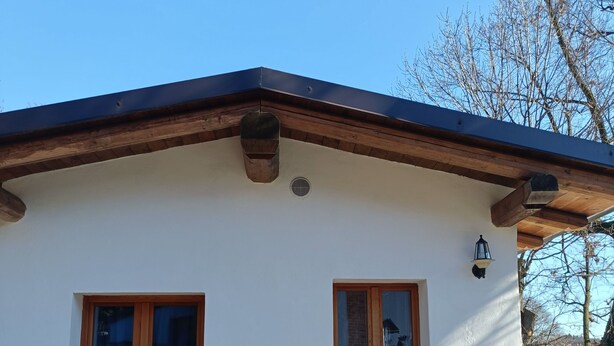 A house with a white exterior, a wooden door, and a window. - The house on the rainbow (Piemonte)