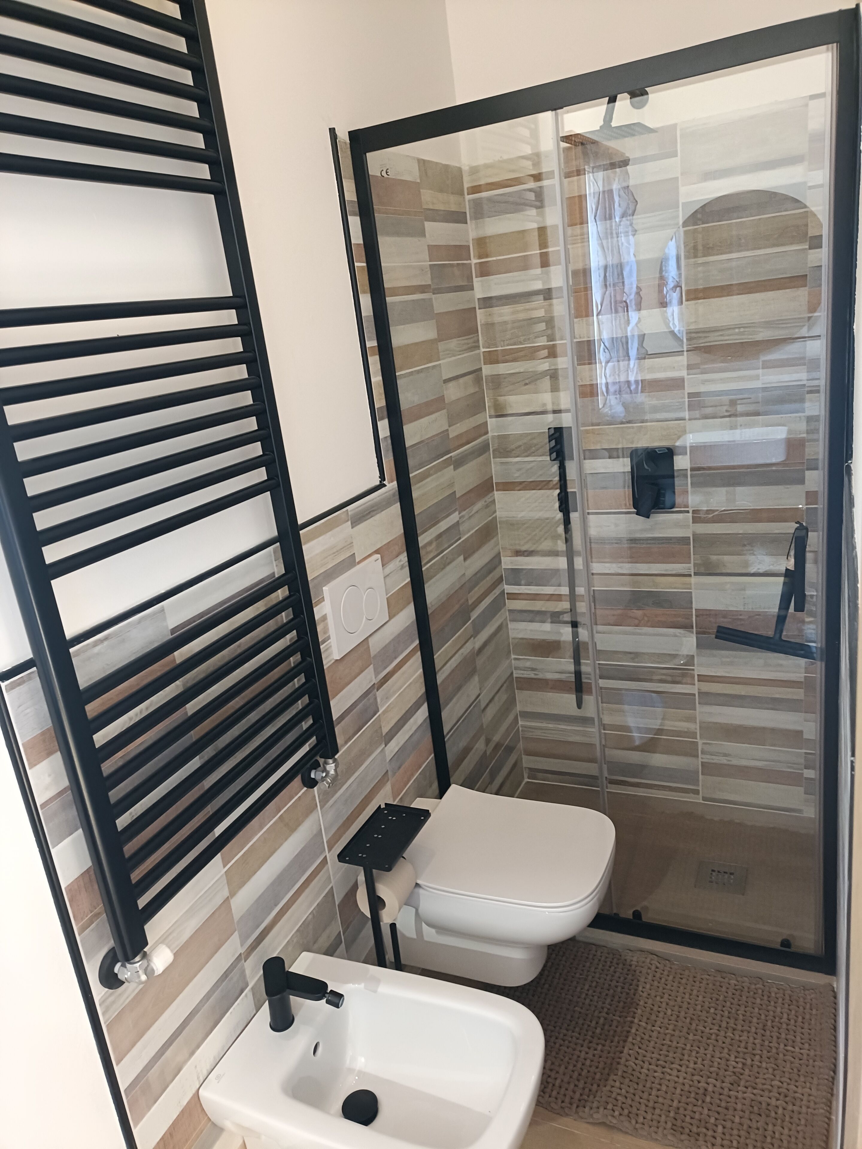 Un baño moderno con cabina de ducha de vidrio, inodoro y lavabo.