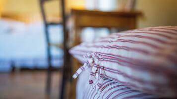 Ein Bett mit gestreifter Bettwäsche und ein Holzbett in einem Zimmer mit Holzboden.