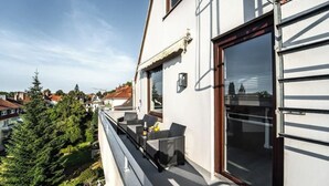 A balcony with outdoor furniture, a window with a view of the city, and a door with a window. - Stern Blick: Maisonette, Balkon, zentral in Bremen (Bremen)
